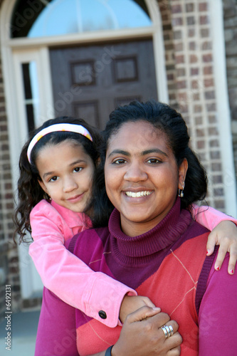 Mom and daughter outside in front of their house photo