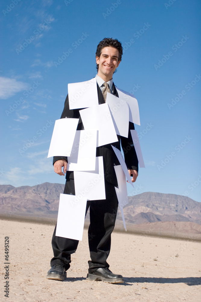 Businessman covered with white papers Businessman covered with white papers