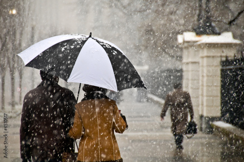 A couple takes a romantic walk in the snow