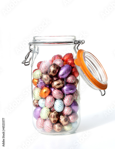 glass jar with chocolate easter-eggs, on white