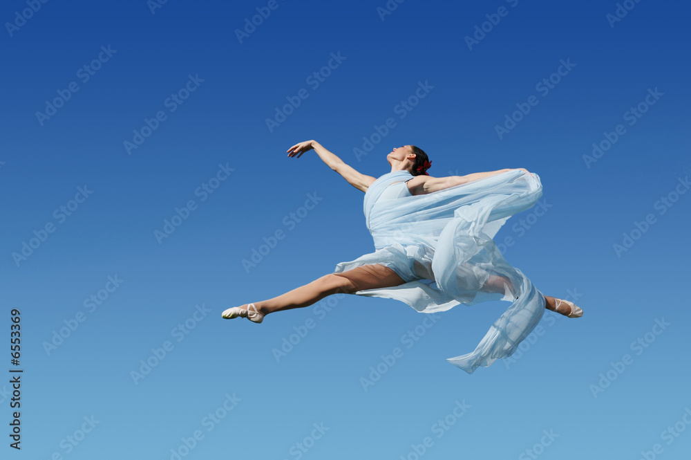 Dancer jumpimp against blue sky