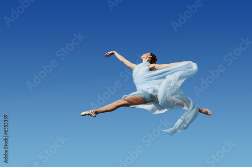 Dancer jumpimp against blue sky