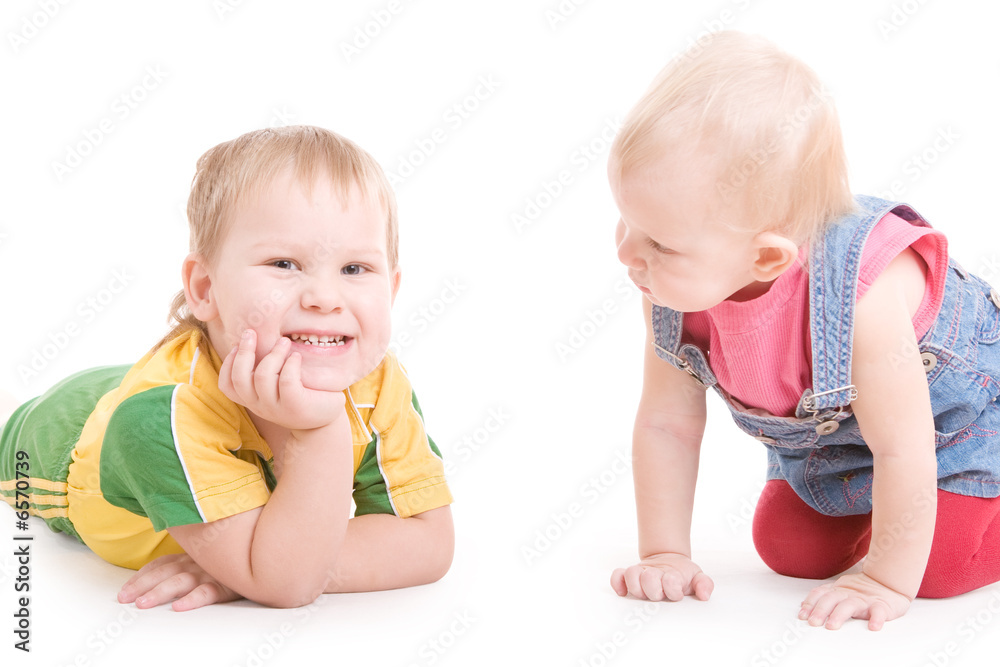 a small girl looks with interest at the smiling boy on the floor a small girl looks with interest at the smiling boy on the floor