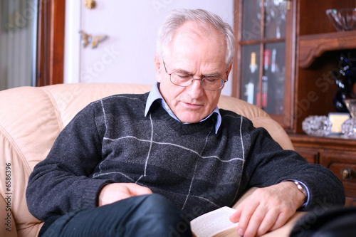 Senior man reading a book (falling asleep while reading)