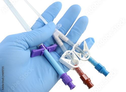 gloved hand holding a catheter and introducer photo