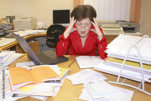 Stress im Büro, Frau sitzt angespannt am Schreibtisch