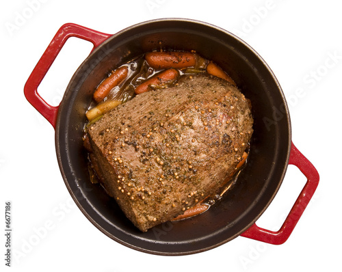 Fotografi Beef roast with baby carrots simmering in a red cast iron pot