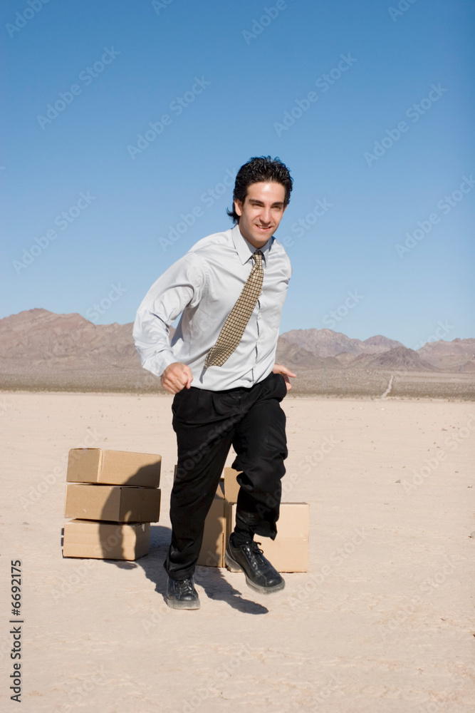 Businesman jumping over boxes