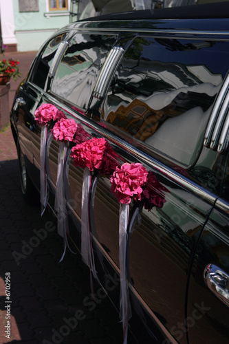 Black wedding limousine with flowers on side