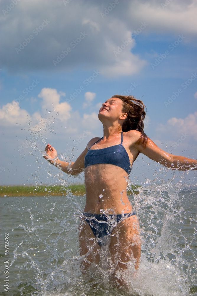 Fototapeta premium girl jumping in water with splashes