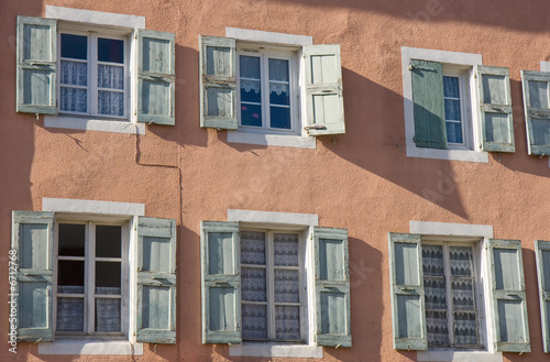 Façade aux murs roses avec six fenêtres aux volets ouverts © Hervé Rouveure
