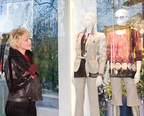 The young woman examining a show-window of shop