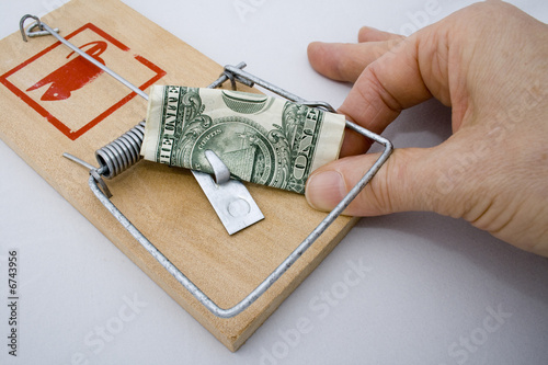 Money Trap - US Dollar being taken from a rat trap