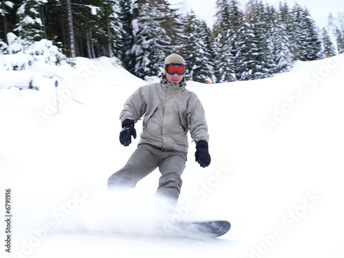 Snowboarder guy sliding on the slope.