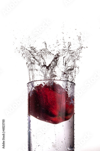 Apple splashing into a glass of water