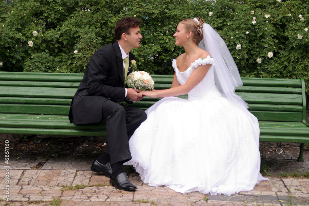 Newlywed bride and groom on bench
