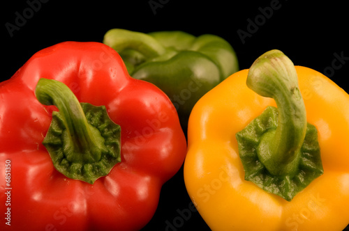 Red yellow and green Bell Peppers on a black background