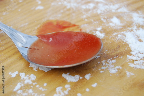 A spoon with red tomato sauce
