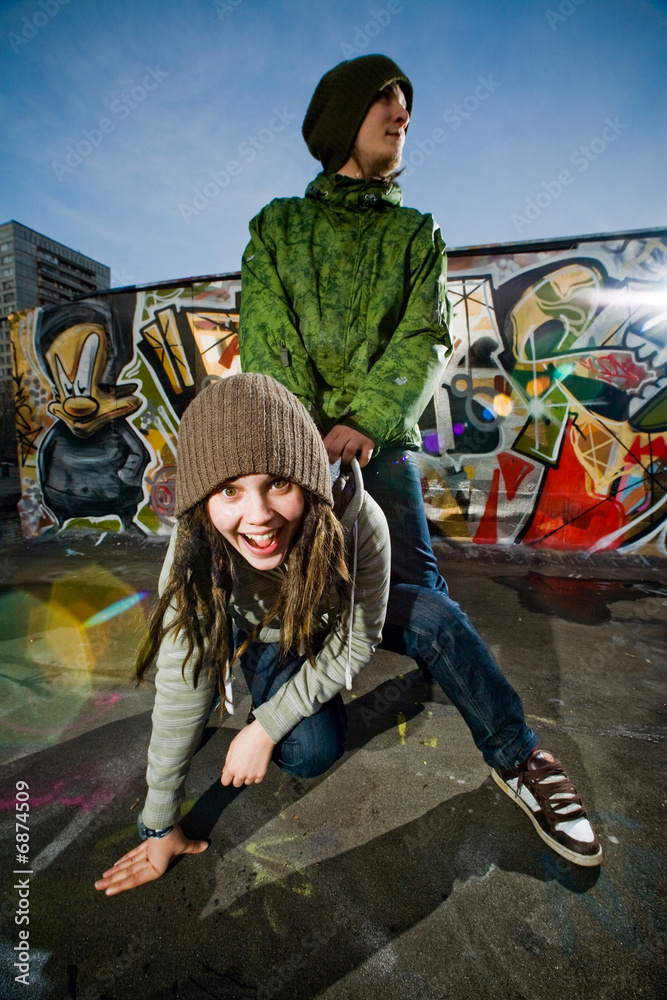 Young boy ang girl pose on a graffity background
