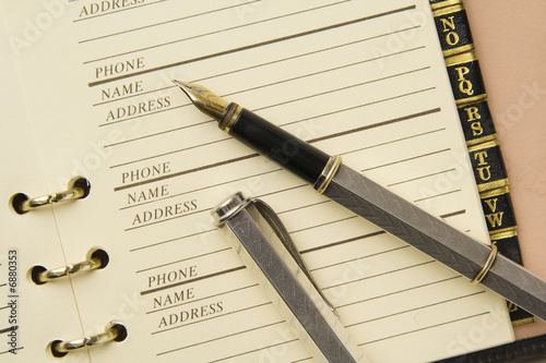 Silver fountain pen on stylish address book