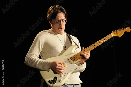 Musician playing guitar in lve concert photo