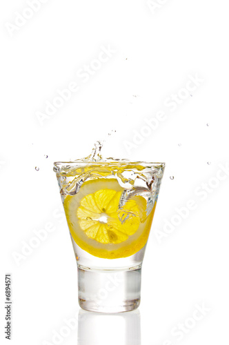 Lemon splashing into martini glass