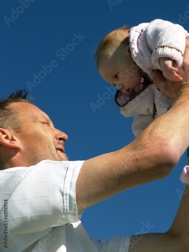 .Father hold baby up in the air