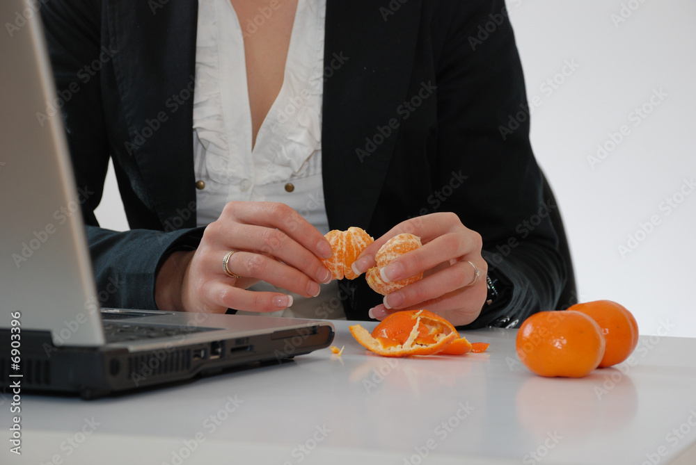 femme mangeant une clémentine au bureau Stock Photo | Adobe Stock