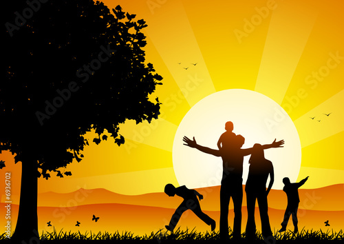 Happy family at sunset under a tree