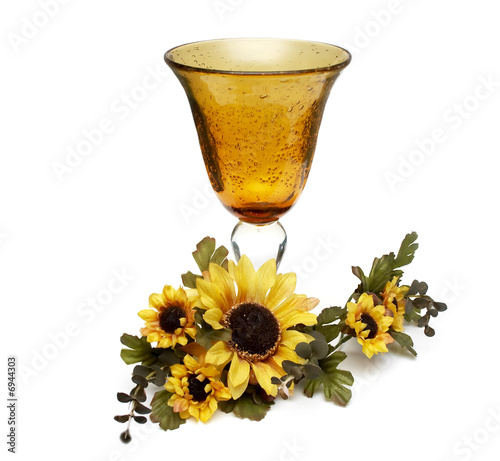 Big yellow wineglass with bouquet of artificial sunflower