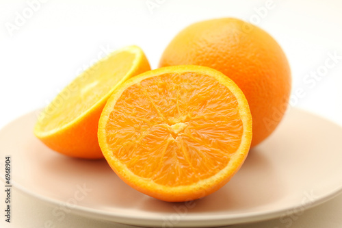 Oranges on plate isolated on white background