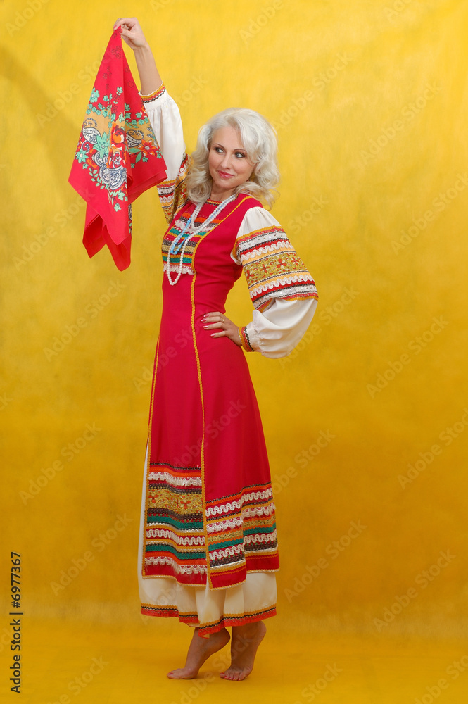 Russian woman in a folk russian dress waves a scarf