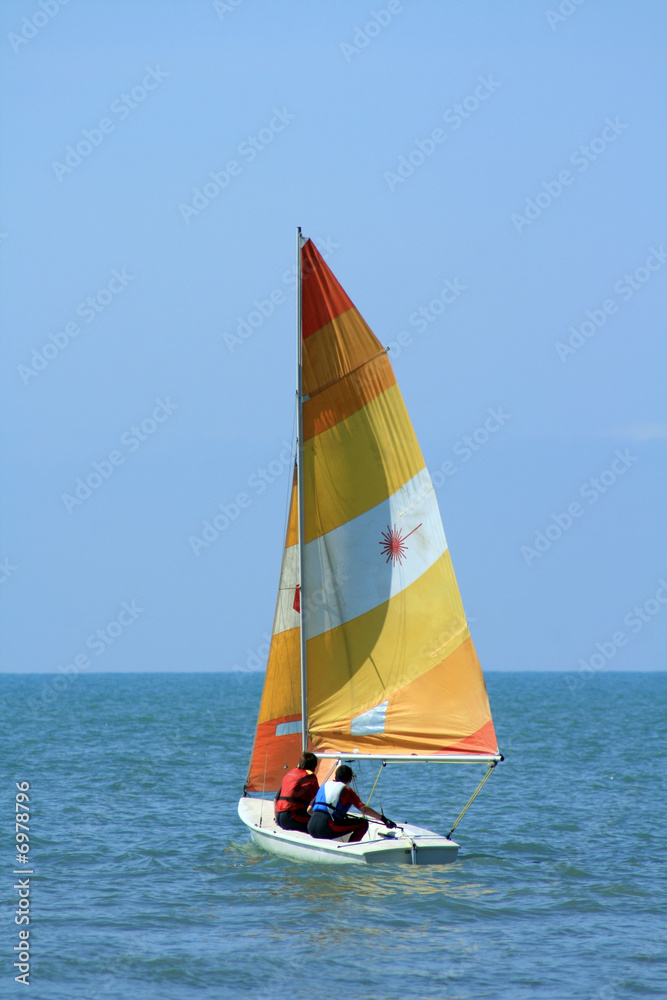 Naklejka premium barca con vela gialla e arancione 2