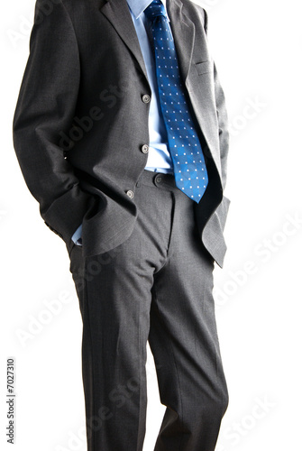 a bussinessman with his hands in his pockets isolated on white