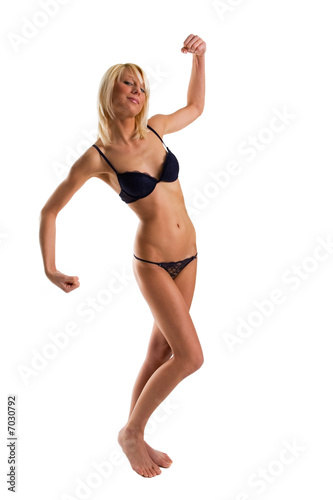 Young girl in pants and bra shows the muscles in nice pose