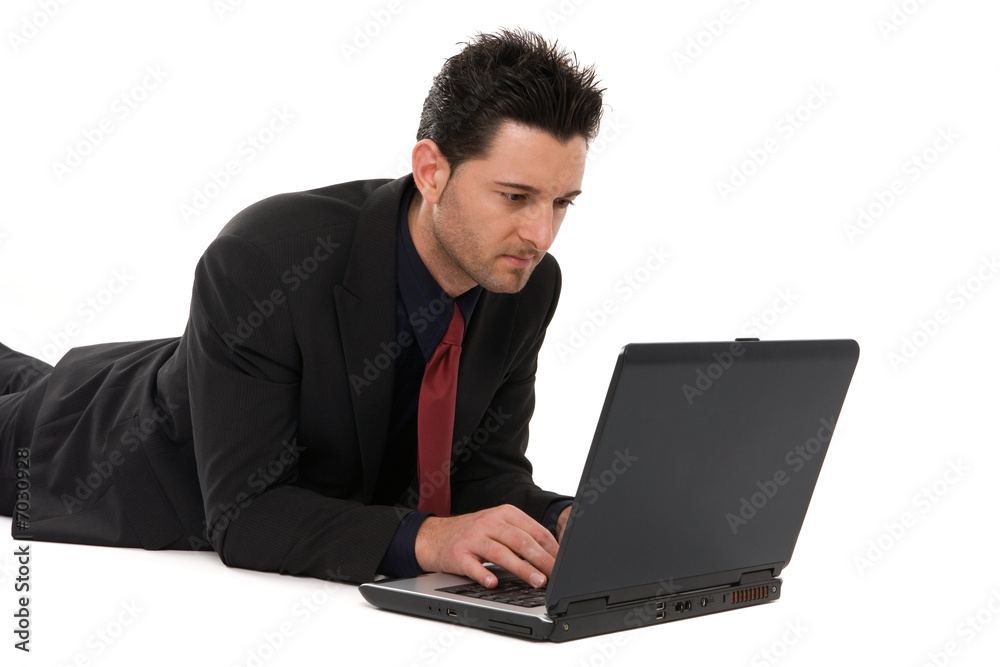 Businessman lying down working with the laptop computer Businessman lying down working with the laptop computer