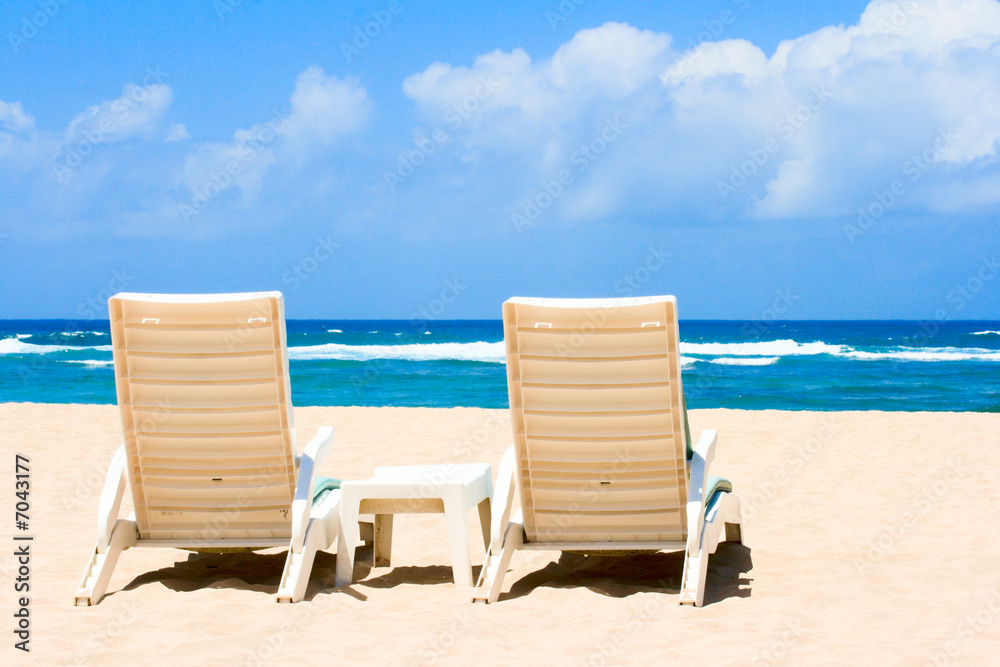 Two sun beach chairs on coast near ocean