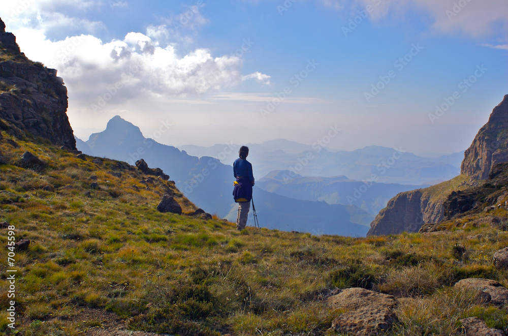 A fit young woman looks out over beautiful distant mountains