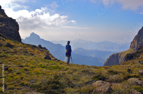 A fit young woman looks out over beautiful distant mountains