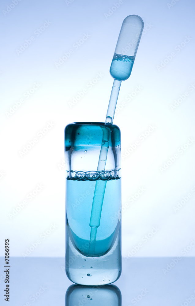 Glass container with blue liquid and measuring stick Glass container with blue liquid and measuring stick