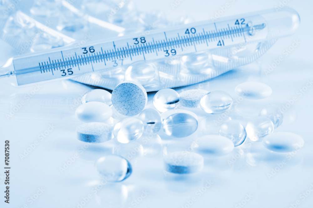 Pills and thermometer in blue tone Pills and thermometer in blue tone