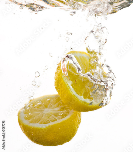 2 Hälften von Zitronen fallen ins Wasser und machen Blasen #7087793