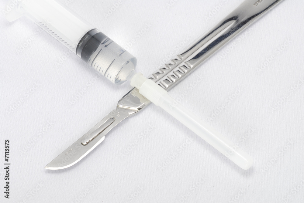 A Surgeon's scalpel and a syringe in a cross A Surgeon's scalpel and a syringe in a cross