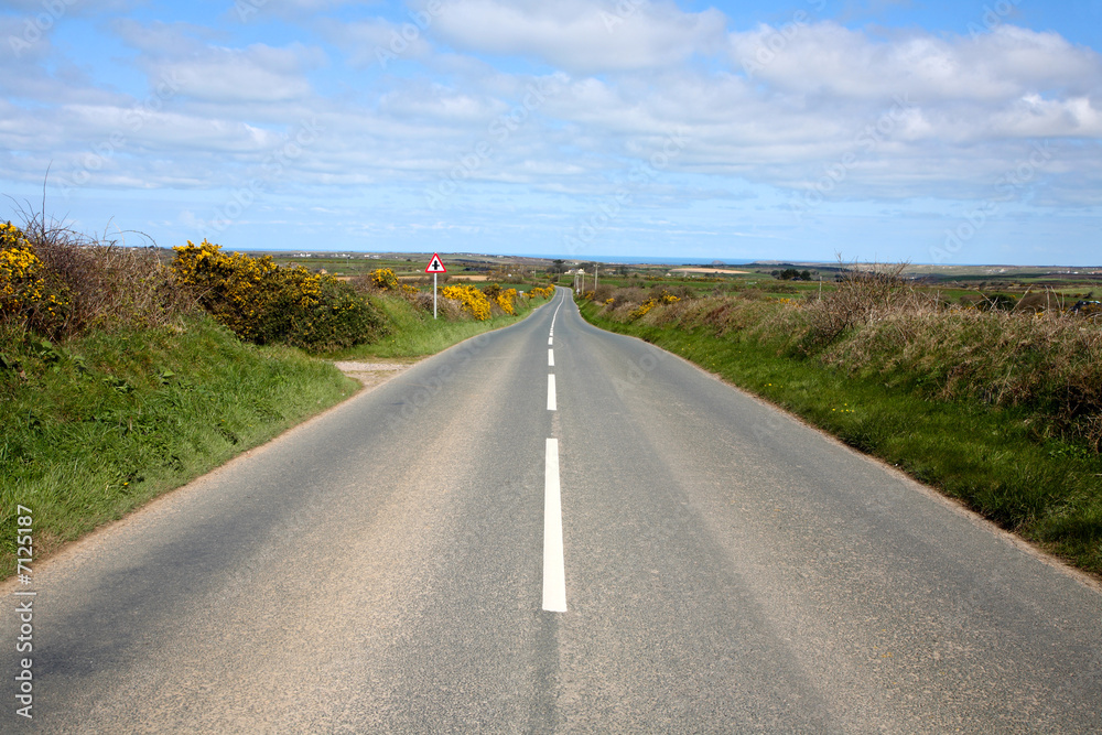 An English country road with the sea on the horizon.