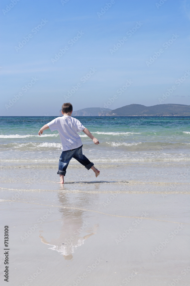 Sardinia, little boy playing on a white sandy Alghero beach, Ca Sardinia, little boy playing on a white sandy Alghero beach, Ca