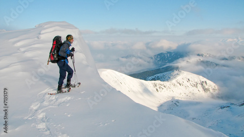 mountaineer enjoying view from the top of the winter mountains