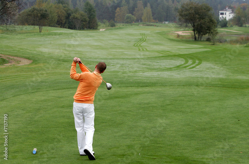 A golfer strikes a tee shot