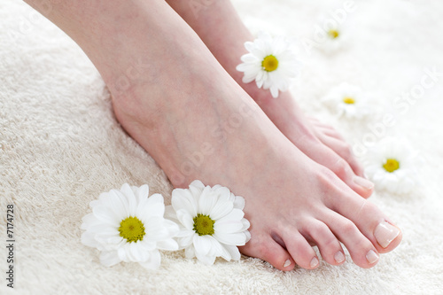 Female feet with white daisies.