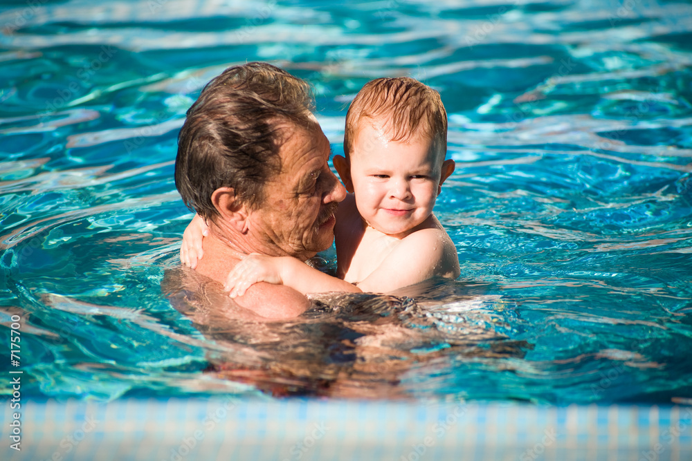 Grandfather swimming with grandson