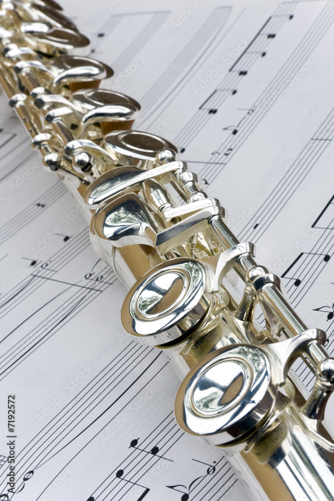 Obraz premium Flute lay across sheet music